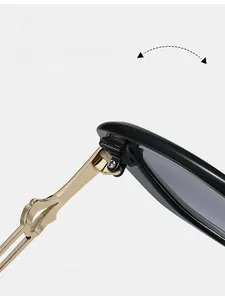 Detail of durable gold-tone metal hinge on black sunglasses with cut-out temple design