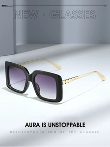 Macro detail of square sunglasses with purple gradient lenses and golden textured temples