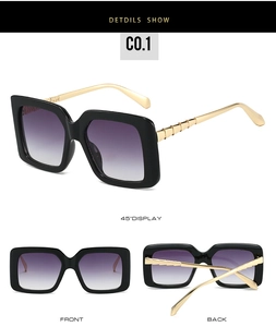 Detail view of square black sunglasses with gold textured metal temples and purple gradient lenses
