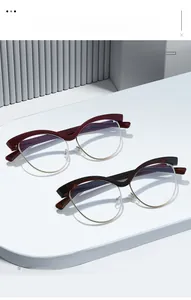 Detailed view of cat-eye eyewear frames in burgundy and black with gold metal rims