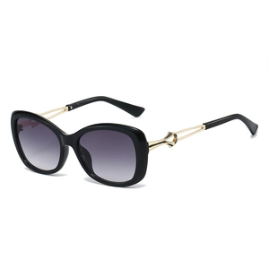 Fashionable sunglasses with black frame, gradient lenses and gold knotted metal temples