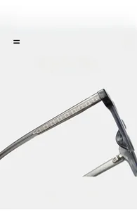 Détail macro d'une branche de lunettes gris transparent avec armature gravée fleurie