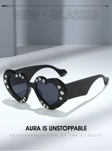 Close-up of heart-shaped sunglasses with sparkling rhinestones on black glossy frames