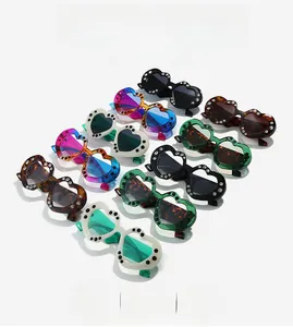 Close-up of heart-shaped sunglasses frames with luxury rhinestone inlay and varied colors