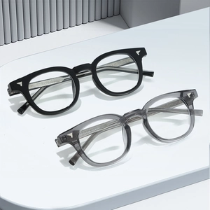 Lunettes anti-lumière bleue TR90 vintage noires et gris transparent sur socle blanc