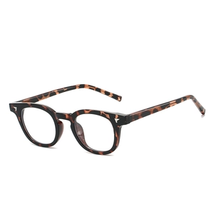Lunettes rondes rétro en TR90 écaille avec détails d'ailes argentées sur fond blanc