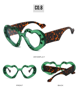 Detail of green heart sunglasses with leopard temples and black studded frame edges