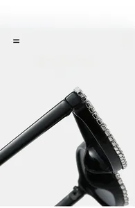 Dettaglio ravvicinato di occhiali da sole cat-eye con eleganti strass argentati su montatura nera