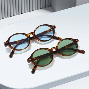 Classic round tortoiseshell sunglasses with light blue and dark green lenses in a chic display