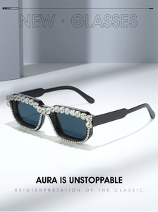Close-up of square black sunglasses with sparkling rhinestones and blue lenses