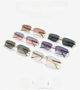 Close-up of rimless rectangular sunglasses featuring gold spiral decorative metal arms