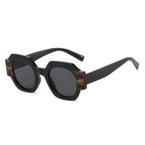 Chunky geometric round sunglasses with black frames and tortoiseshell accents in side view