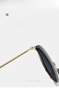 Detail of golden metal temple with fine texture and flexible hinge on round sunglasses