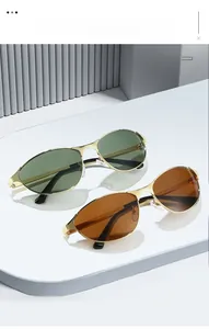 Detail of vintage oval metal sunglasses with gold frames and green or brown lenses