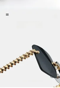 Detail van randloze zonnebril met goudkleurige metalen poten voorzien van rockstud textuur en veerkracht