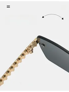 Detail van goudkleurig scharnier en metalen pootje met golfpatroon op randloze zonnebril
