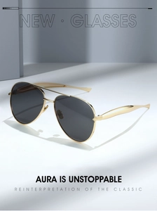 Detail of aviator sunglasses with gold metal frame and dark grey lenses in studio lighting