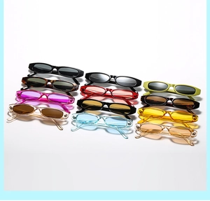 Flat lay of retro narrow rectangular sunglasses in eleven vibrant assorted colors