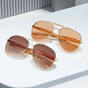 Retro pilot sunglasses with gold metal frame and orange tinted lenses in a stylish pair