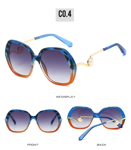 Detail of oversized sunglasses with tiger pattern frames, pearl temples and gradient lenses