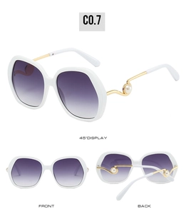 Detail view of large white sunglasses with purple gradient lenses and pearl-accented temples