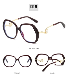 Detail view of burgundy oversized sunglasses with gold metal temples and pearl accents