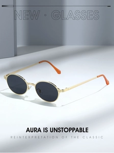 Detail of gold metal oval sunglasses with dark lenses and orange temple tips on a blue base