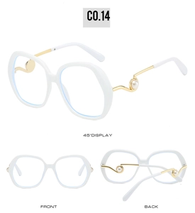 Detail of white oversized sunglasses with gold wavy temples and pearl embellishments
