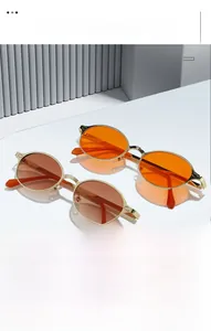 Detail of vintage oval metal sunglasses with orange and brown gradient lenses and gold frames
