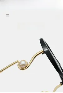 Detail of golden wavy metal temples with white pearl accents on large frame sunglasses