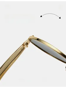 Close-up of durable golden metal hinges on oval sunglasses with high-gloss mirror finish