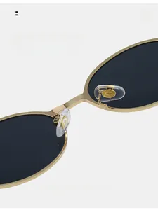 Macro shot of gold metal sunglasses nose pads with transparent silicone and logo detail