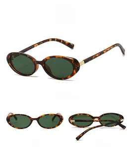 Detail view of tortoiseshell oval frame sunglasses with dark green lenses and gold rivets