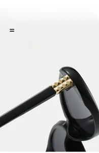 Detail of durable metal hinge with golden pyramid texture on black eyeglass frame
