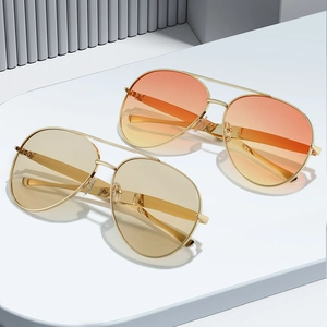 Classic aviator sunglasses with gold metal frame and yellow gradient lenses in chic setting