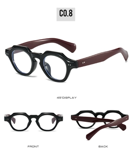 Detail of retro round glasses with thick black frames and burgundy temples with silver rivets