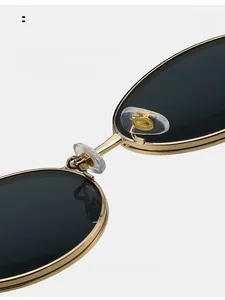 Detail of adjustable silicone nose pads and golden metal bridge on retro sunglasses