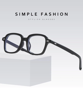 Detail of square black glasses frame with silver metal rivets on white geometric stand
