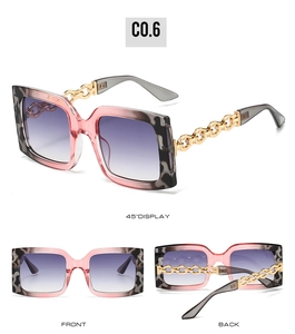 Detailed view of square sunglasses with leopard print frame and golden chain temples