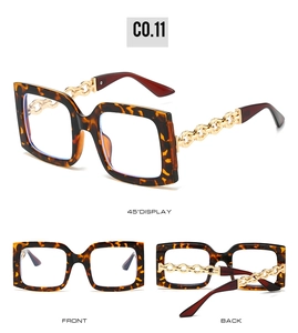 Detailed view of tortoiseshell square sunglasses with gold metal chain temple design