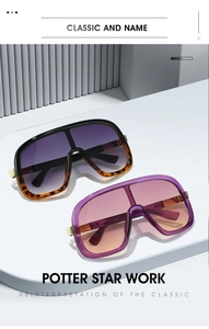 Detail of oversized shield sunglasses with gold metal hinges and gradient lenses