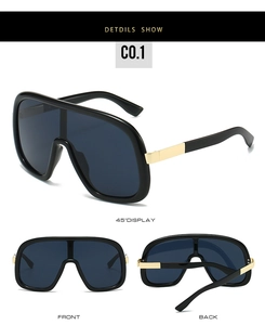 Detail view of large shield sunglasses with glossy black frames and gold metal accents