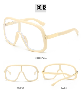 Detail view of cream-colored oversized sunglasses with gold metal hinges and thick nose pads
