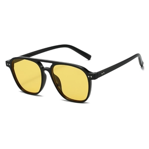 Lunettes de soleil pilote rétro avec monture noire et verres jaunes, style vintage urbain