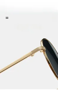 Détail de la charnière en métal doré avec rayures sur des lunettes de soleil rondes