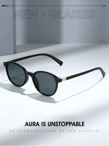 Vue détaillée des lunettes de soleil rondes noires avec accents métalliques dorés gaufrés