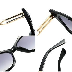 Lunettes de soleil œil de chat, monture noire, branches dorées et verres dégradés