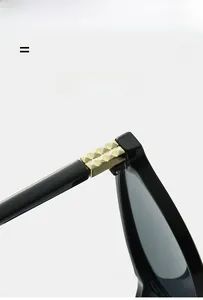 Détail macro des clous dorés sur les branches de lunettes de soleil rondes noires