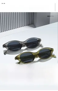 Vue détaillée de lunettes de soleil œil-de-chat rétro en olive et gris sur un socle