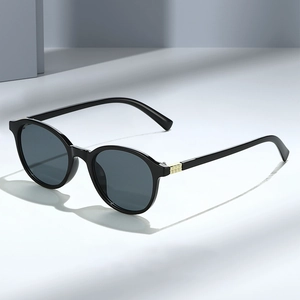 Lunettes de soleil rondes vintage avec verres foncés et détails géométriques dorés fins